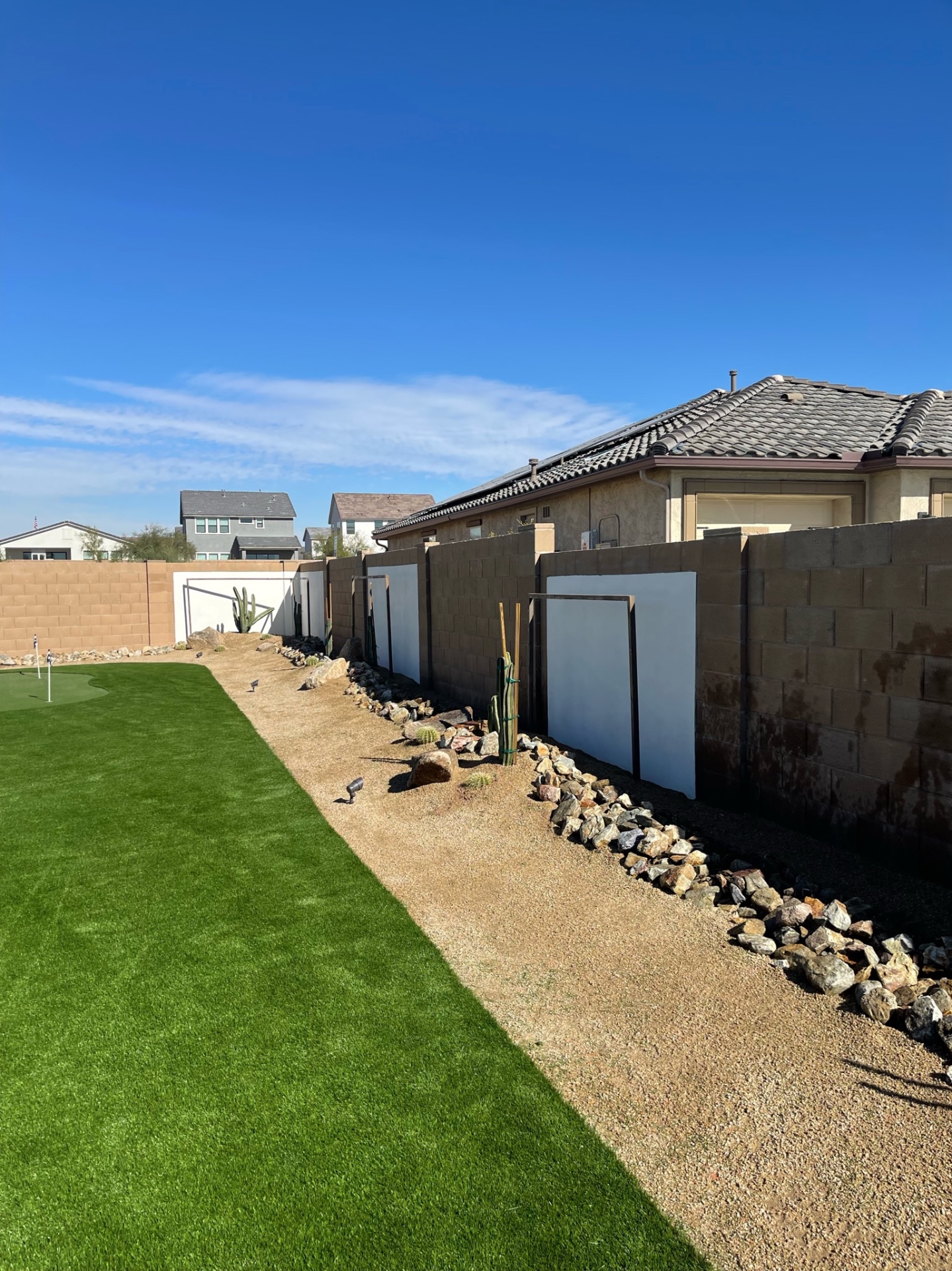 Goodyear side-yard artificial turf runway with rock border, cactus and stucco privacy walls