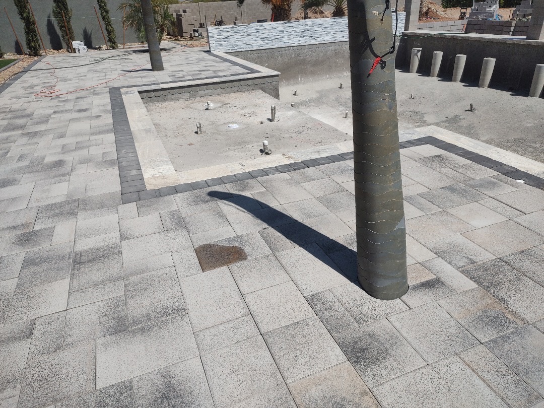 Paver deck installed around a recessed feature with scalloped edge and banded paver border