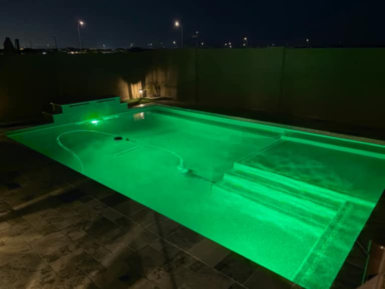 Color-changing LED pool lighting at night.