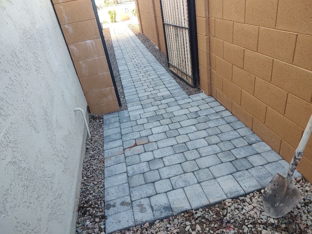 Vistancia (Peoria) side-yard paver walkway in tumbled grey pavers running between stucco house wall and painted block boundary wall to backyard gate by AE Outdoor Living