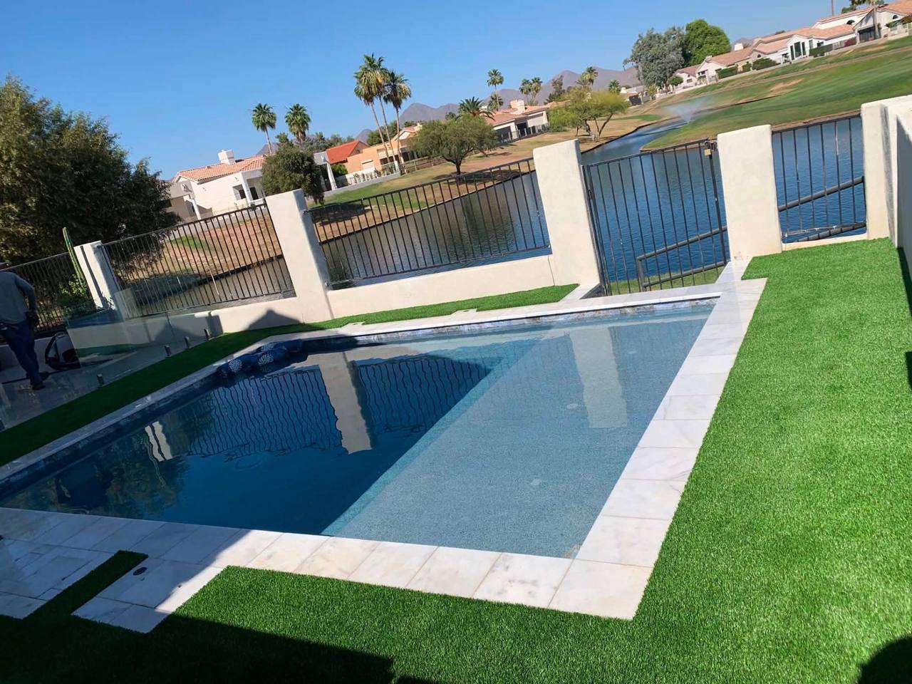 Custom Arizona pool with travertine deck, raised spa, and water features by AE Outdoor Living