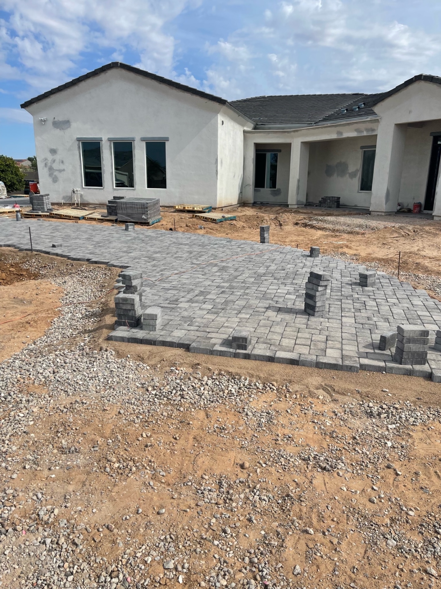 Waddell (Surprise-area) charcoal paver rear patio spanning the full back of a single-story stucco home with covered ramada opening by AE Outdoor Living
