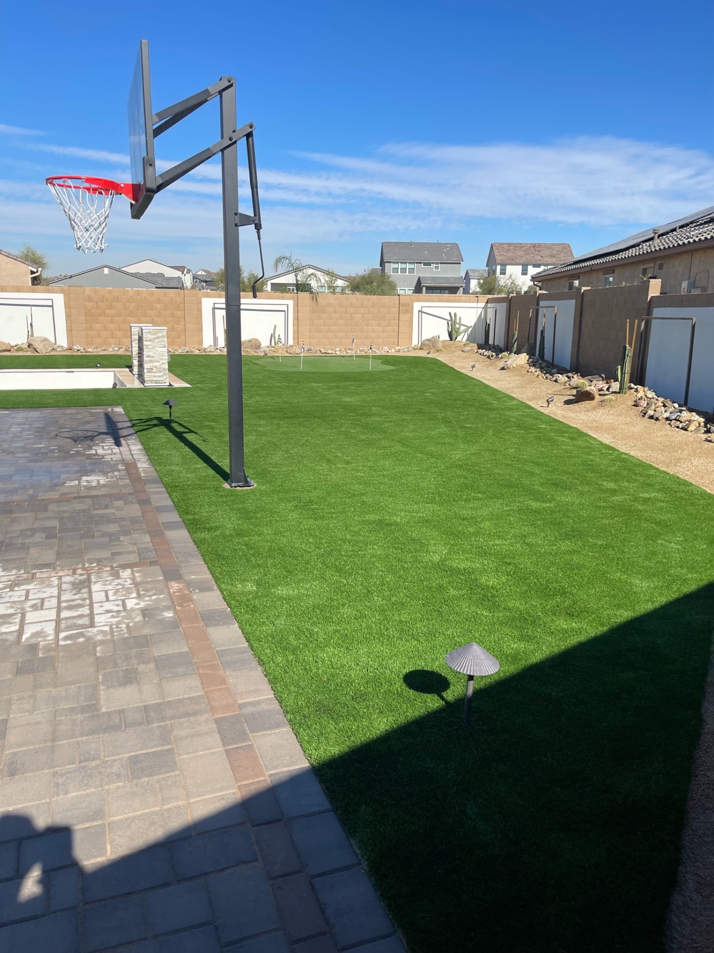 Goodyear backyard artificial turf lawn with in-ground basketball hoop, paver sport court and putting green