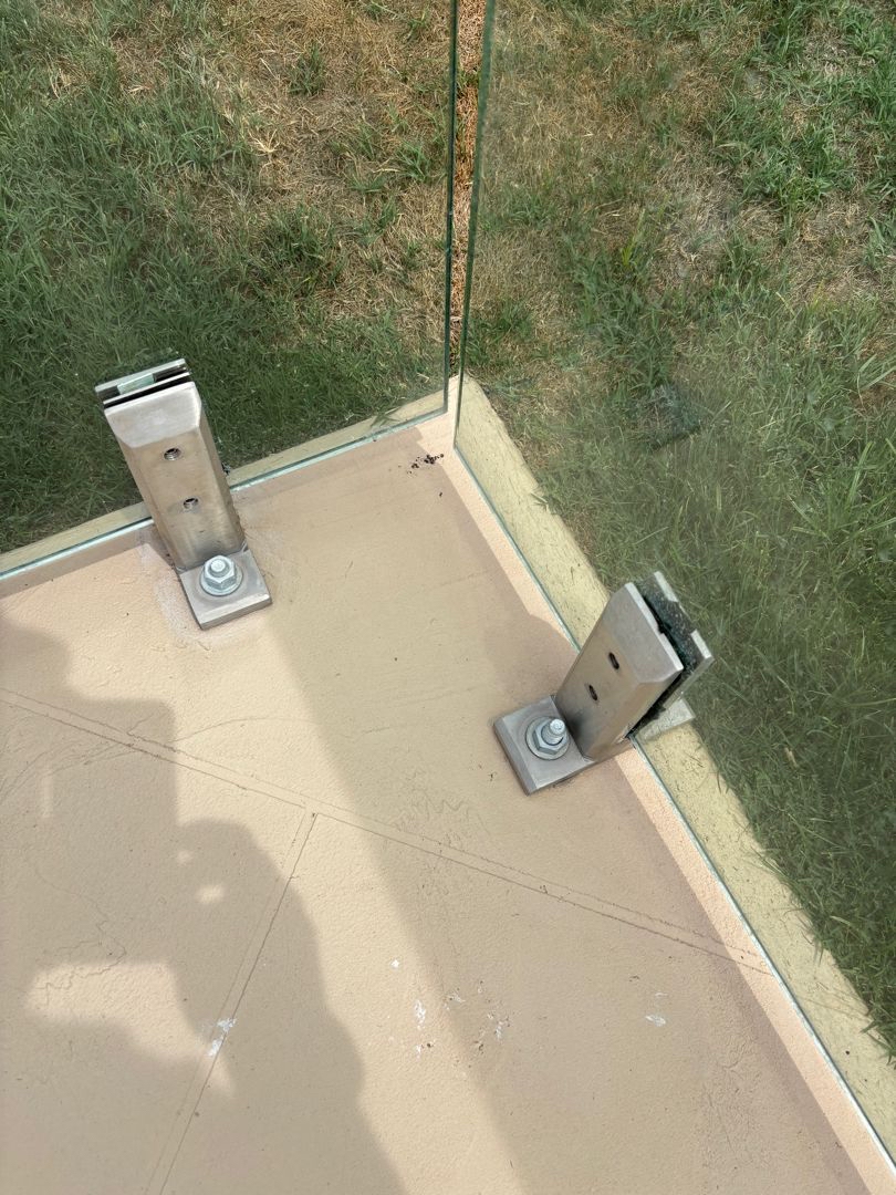 Close view of a stainless base-plate spigot visible at a painted decorative finish surface.