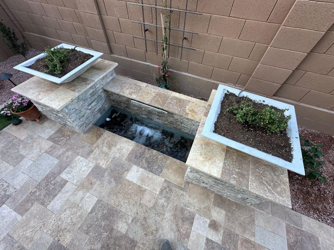 Aerial view of a Peoria travertine patio, spillway water feature, and matched planter columns