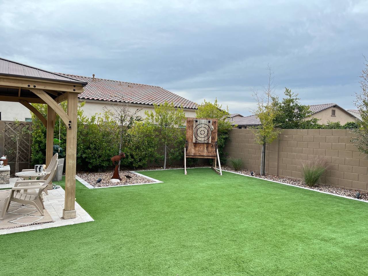 Vask residence The Meadows Peoria AZ turf play lawn with axe-throwing target, planted rock beds, and cedar gazebo corner