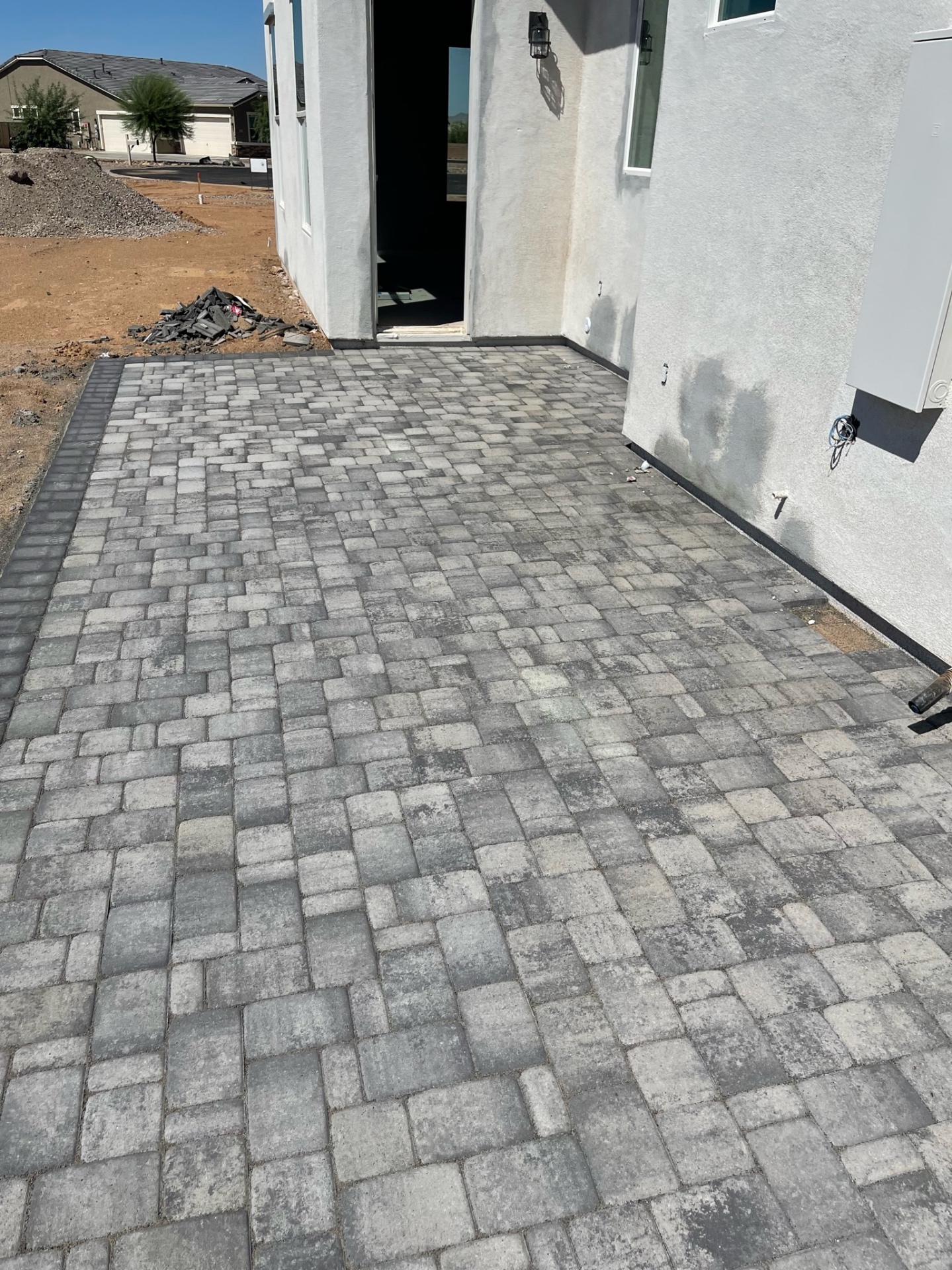 Waddell (Surprise-area) finished front-entry paver landing with two-tone grey tumbled field and charcoal soldier-course border by AE Outdoor Living