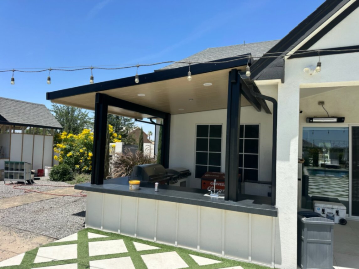 Built-in outdoor kitchen with BBQ island, stone veneer, counter, storage, and low-voltage lighting