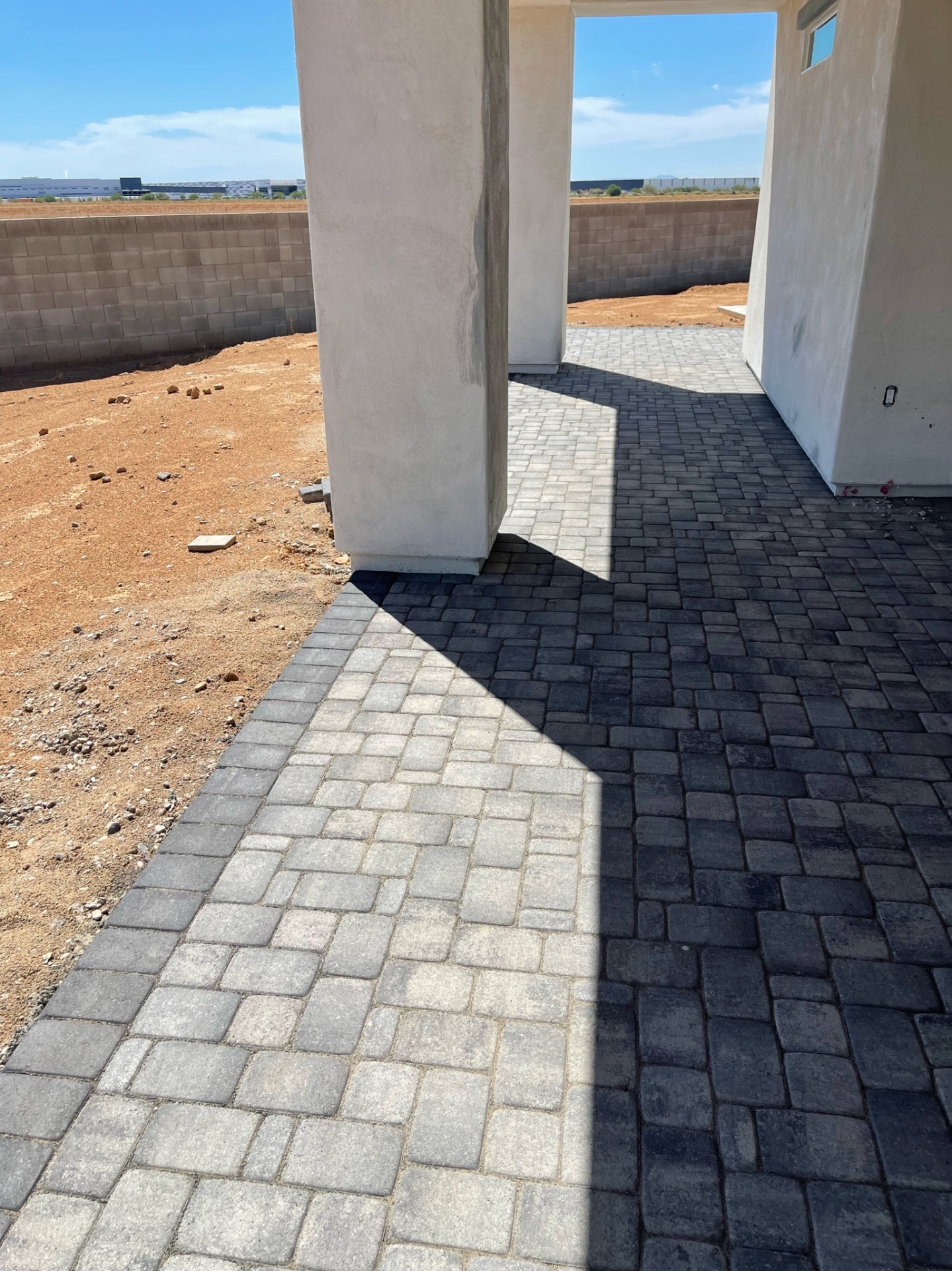 Waddell (Surprise-area) breezeway paver walkway blending light-grey and charcoal tumbled pavers between the home and open desert lot by AE Outdoor Living