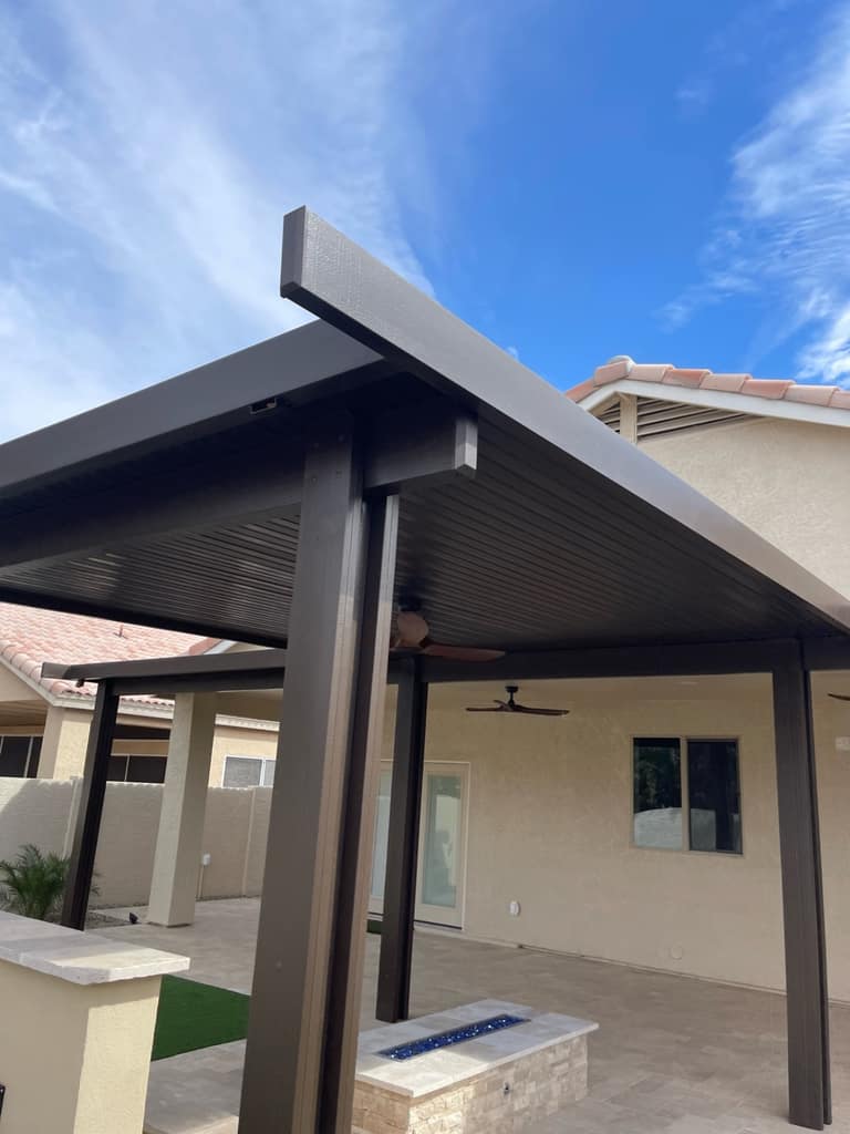 Pergola structure detail over a finished fire feature and travertine-style patio.
