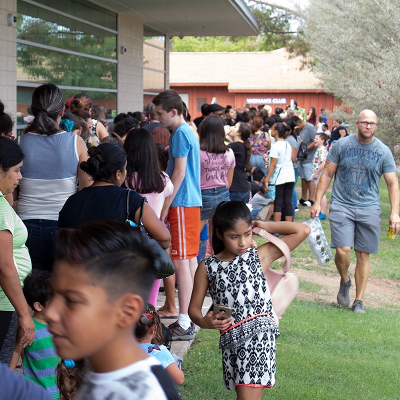 Long line of families waiting outside the community center during the backpack drive