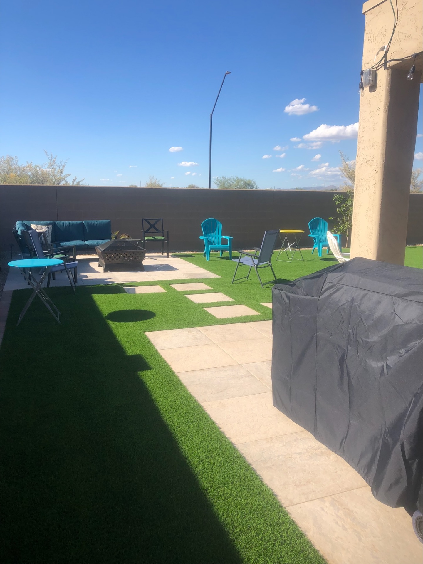 Buckeye covered patio in travertine pavers with adjacent turf lawn and grill station