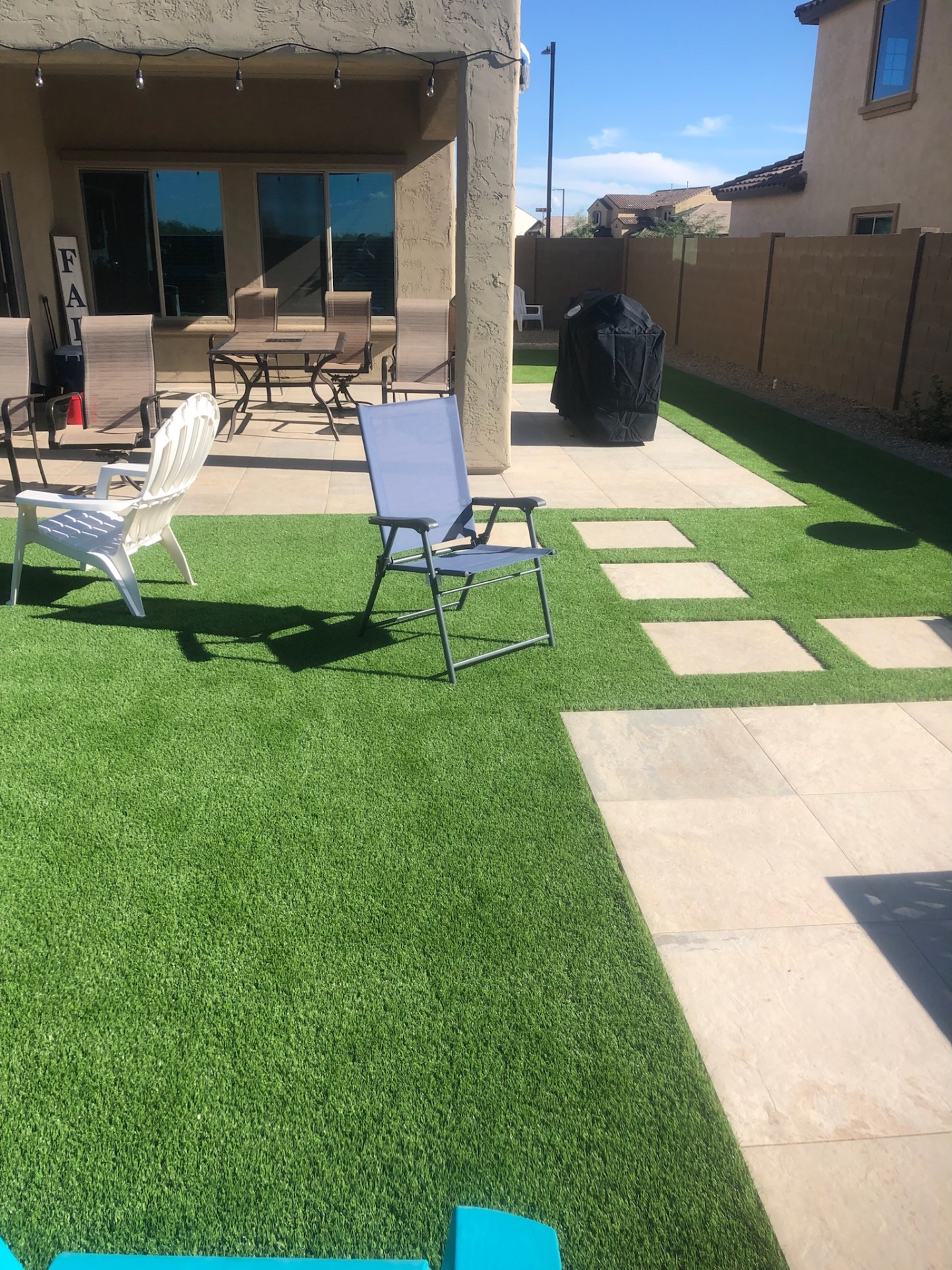 Buckeye artificial turf and paver ribbon design leading to covered patio