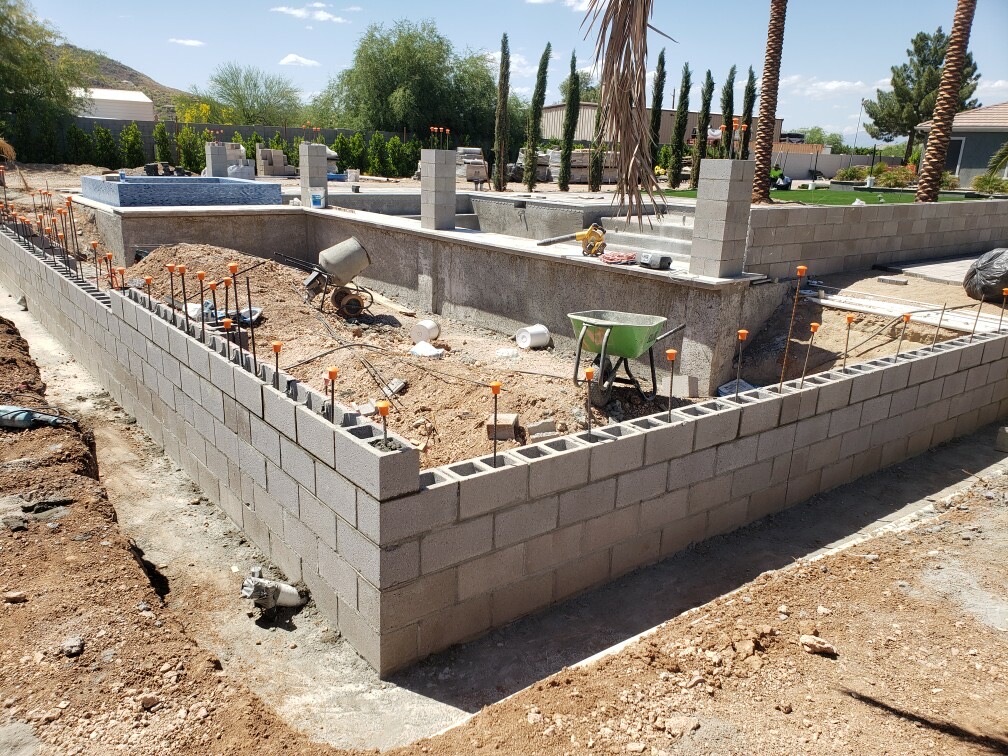 Finished cinder block perimeter wall with vertical rebar awaiting cell-fill