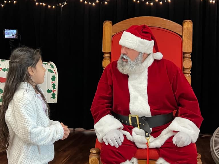 Young girl talking with Santa at Peoria Police Shop With a Cop event