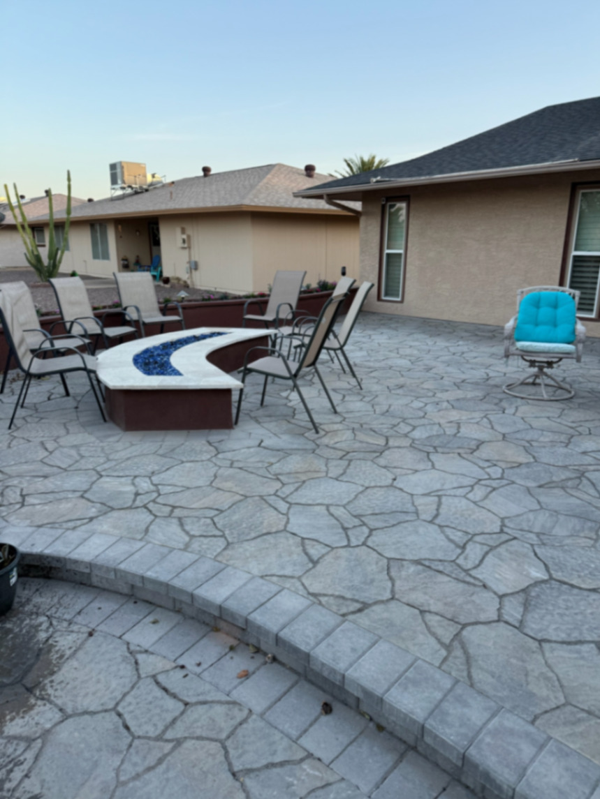 Thorn residence, Mesa AZ — curved custom fire pit with blue fire glass on a flagstone-pattern paver patio bordered by a charcoal soldier course.