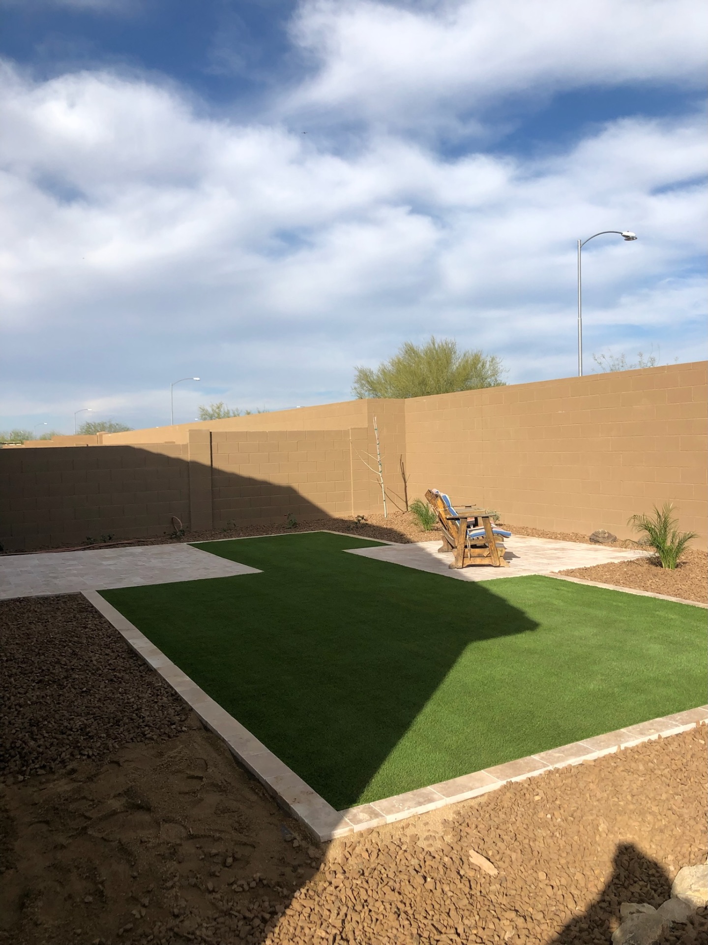 Verrado turf lawn install with travertine paver perimeter and paver patio landing