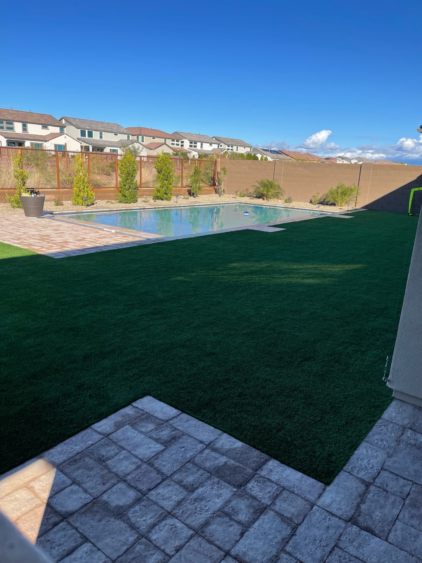 Peoria rectangular pool with paver pool deck, full artificial turf lawn and stamped concrete patio in new-build backyard by AE Outdoor Living