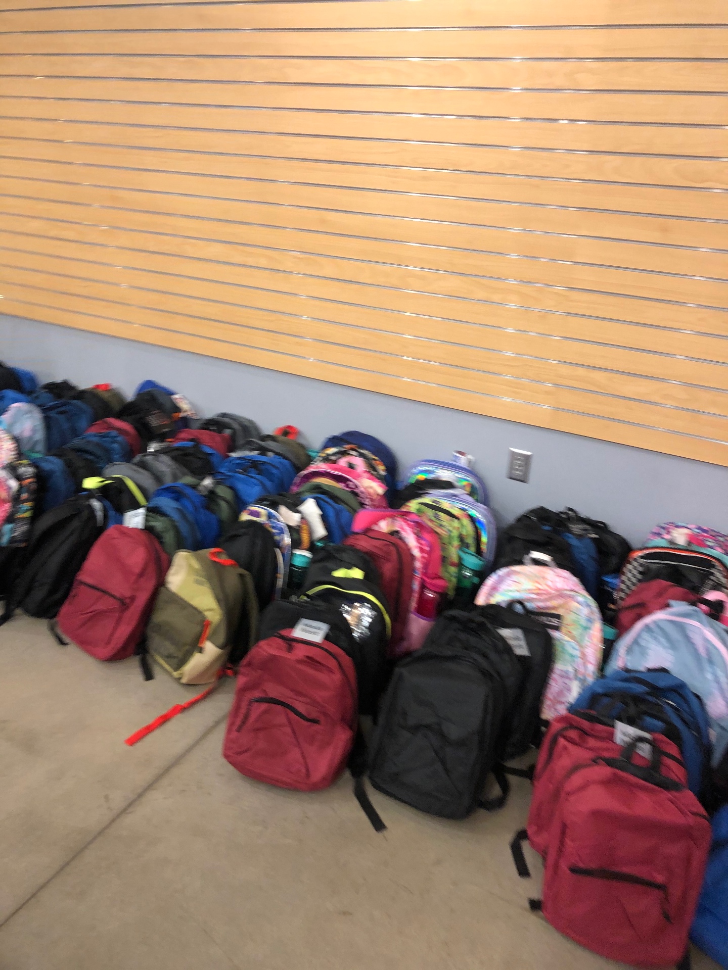 Close-up of finished backpacks stuffed with school supplies and tagged for handoff