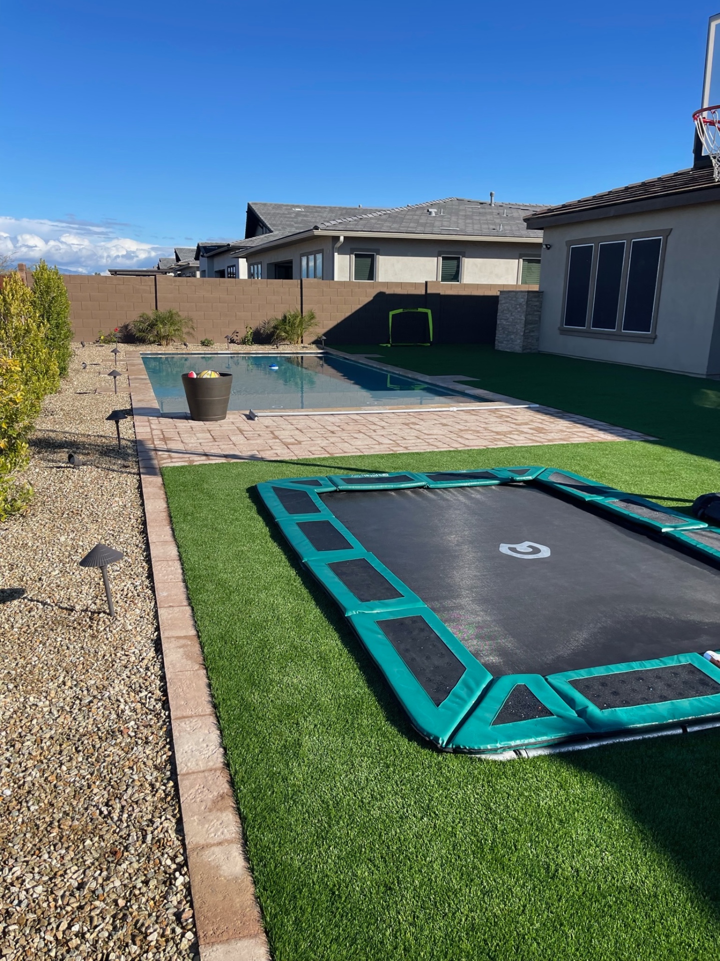 Peoria rectangular pool with paver deck, artificial turf sport lawn and in-ground trampoline in complete backyard build by AE Outdoor Living