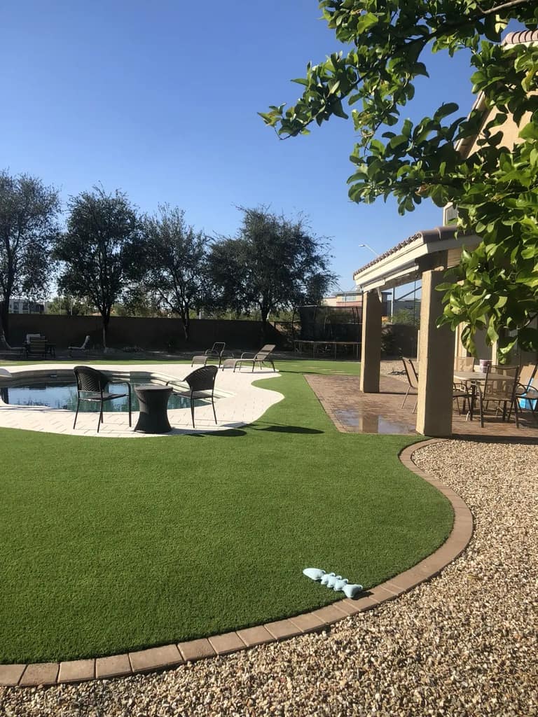 Artificial turf connecting a covered paver patio with the poolside seating area in a Glendale backyard.