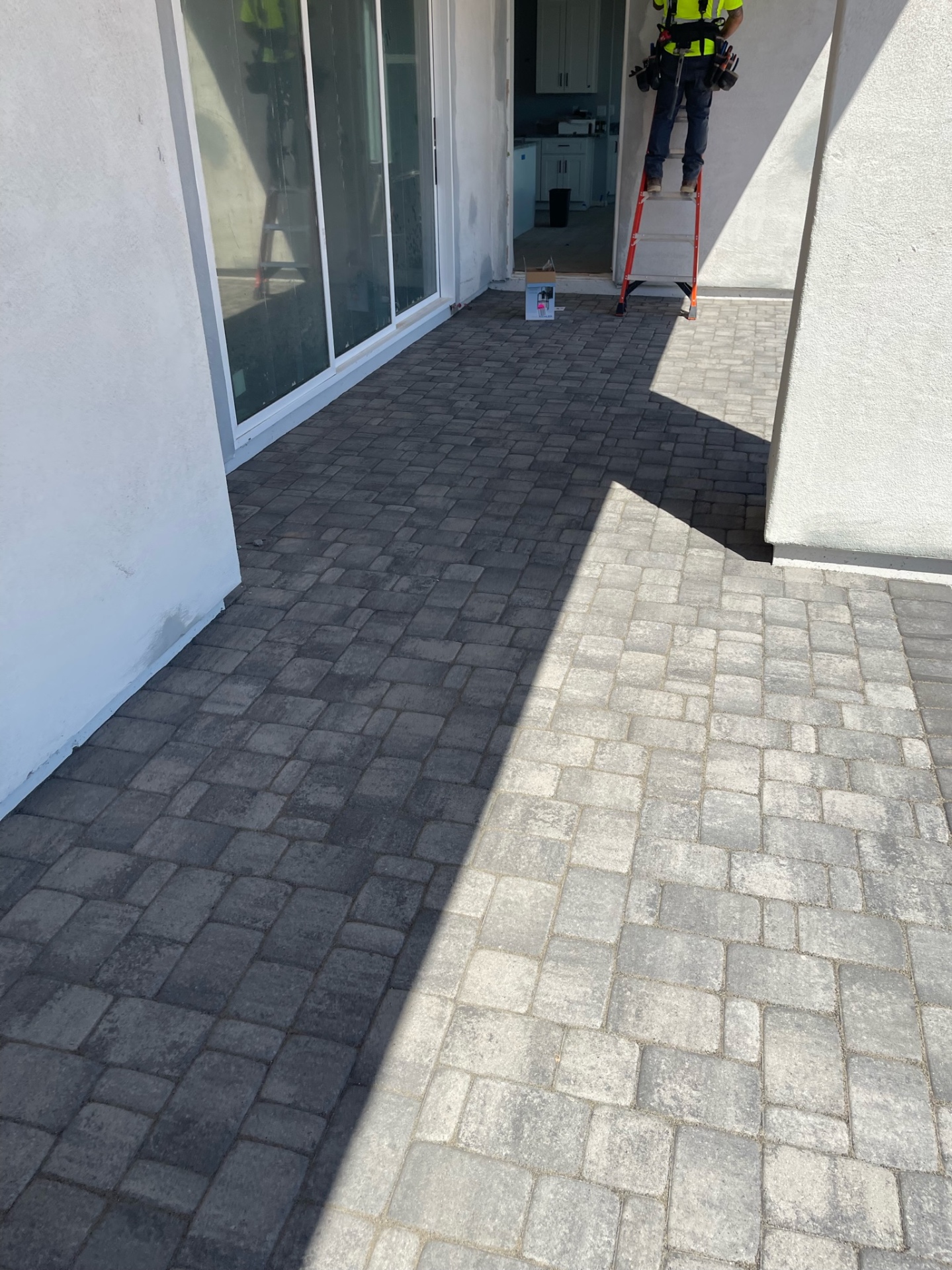 Waddell (Surprise-area) rear patio showing the charcoal-to-light-grey paver color transition running out from the sliding glass door by AE Outdoor Living
