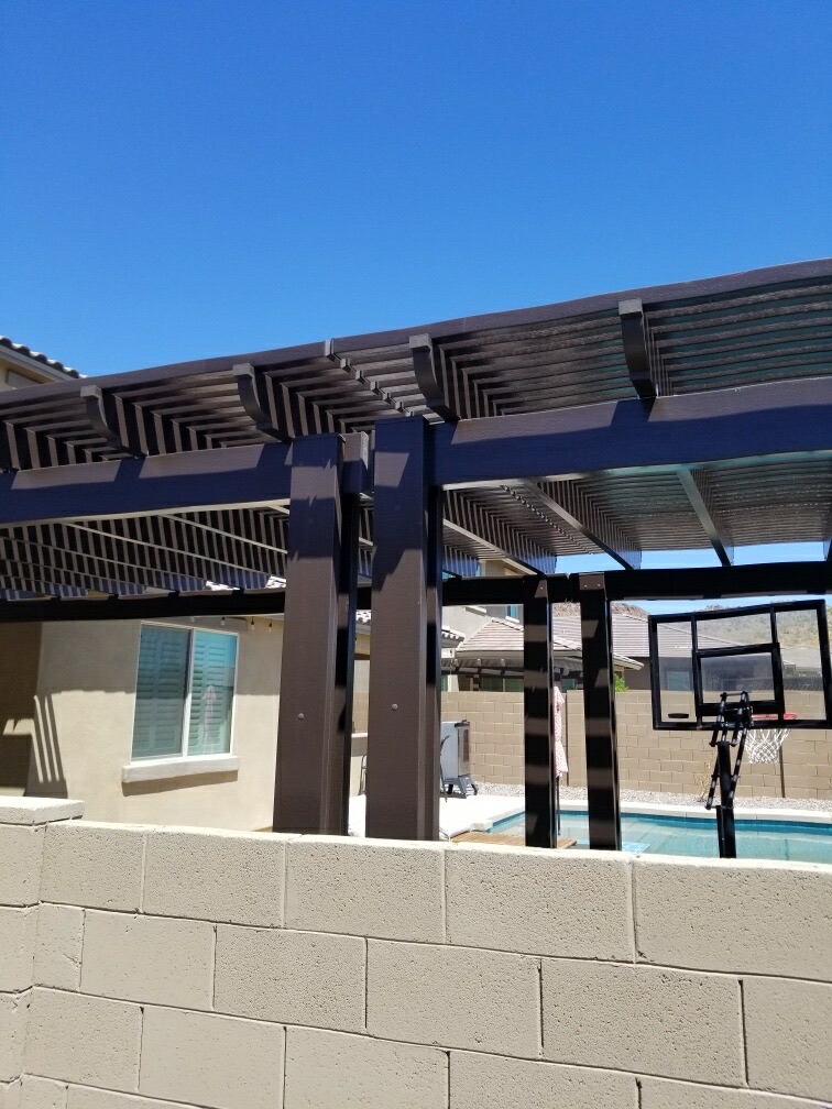 The Meadows (Peoria) bronze alumawood pergola detail with heavy structural posts, lattice rafters and end-cut fascia over pool patio with basketball hoop and mountain view