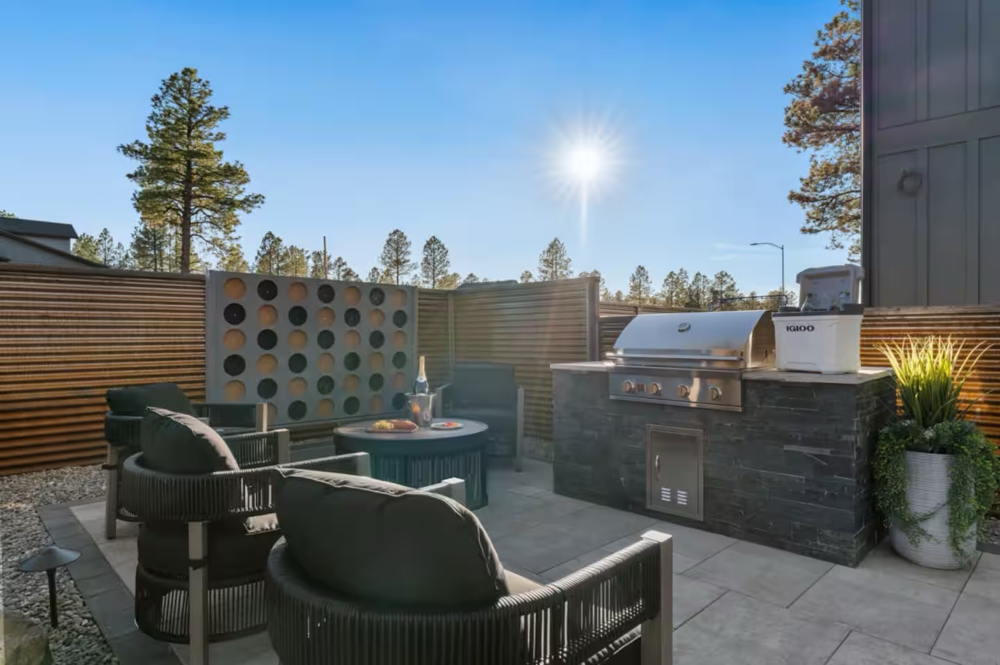 Built-in outdoor kitchen with BBQ island, stone veneer, counter, storage, and low-voltage lighting