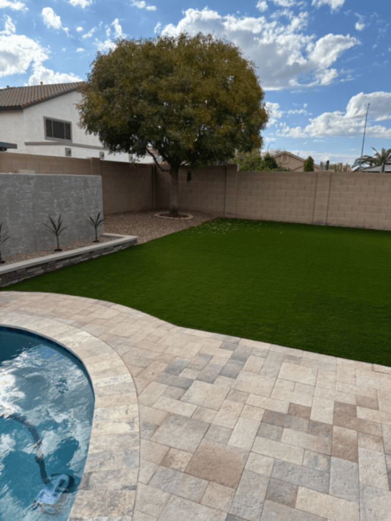 Thorn residence, Mesa AZ — turf lawn wrapping the pool corner with raised planter and agave accents.