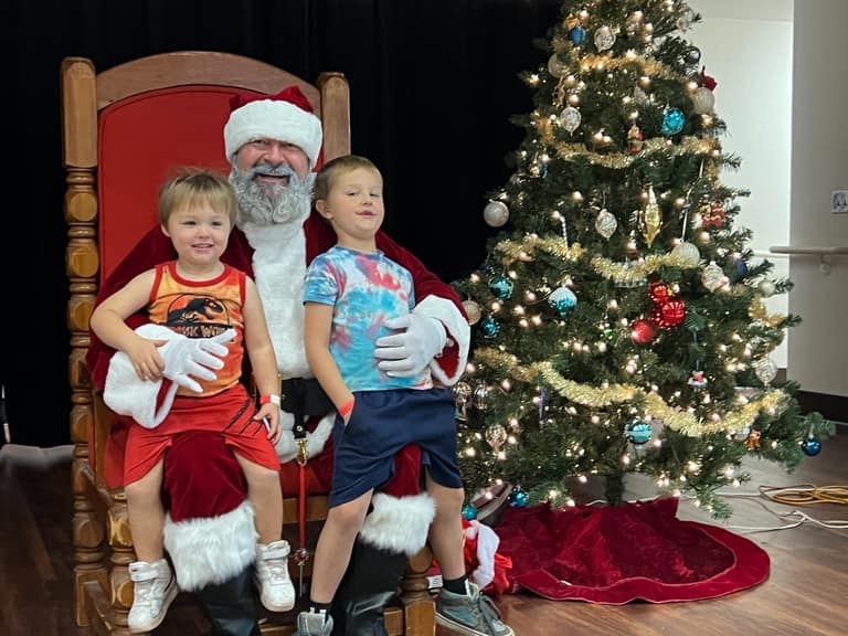 Two young brothers sitting with Santa at Shop With a Cop event