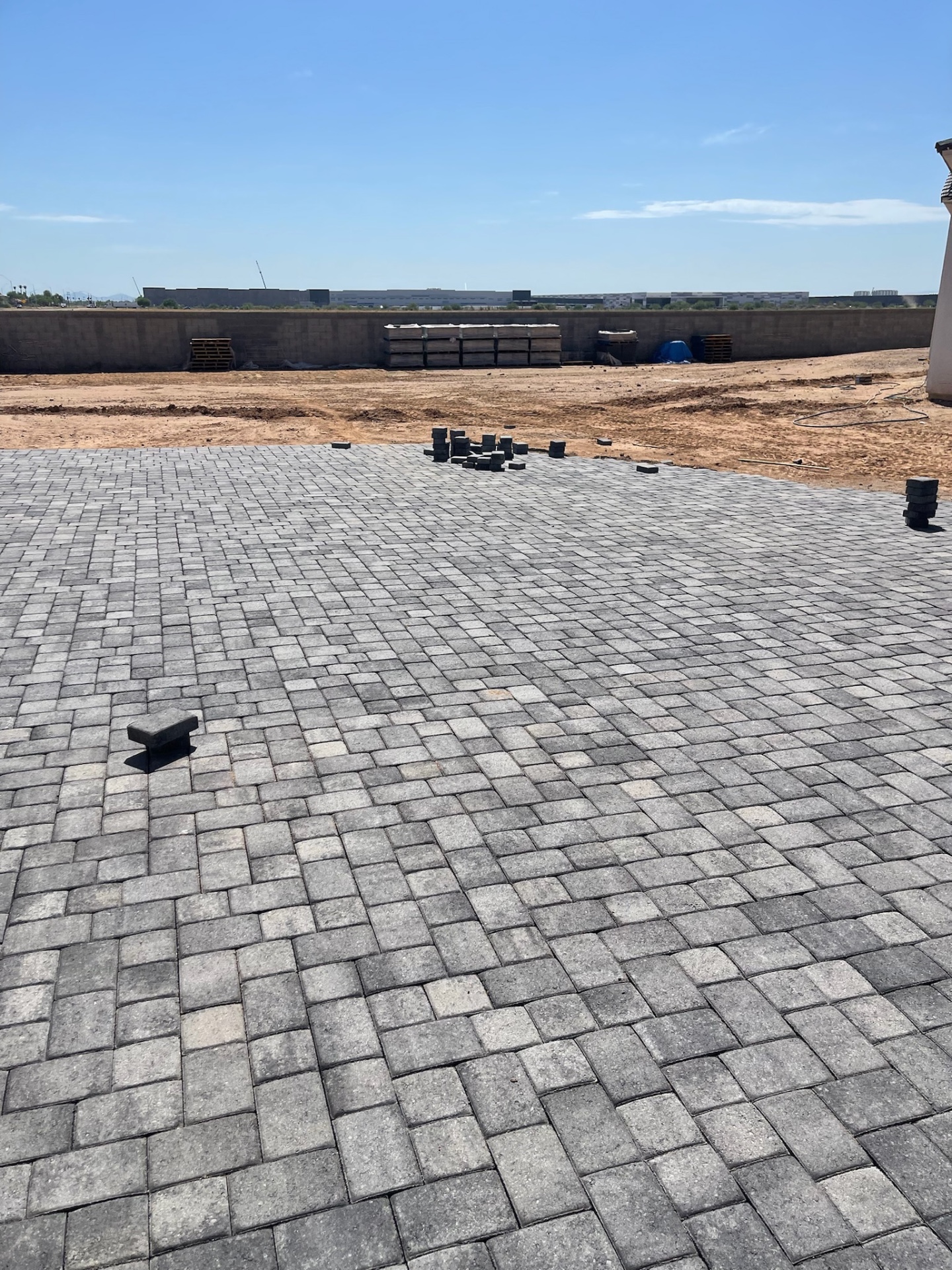 Waddell (Surprise-area) large charcoal paver backyard installation with open field pattern and staged edge pieces across the 12,000 sq ft project by AE Outdoor Living