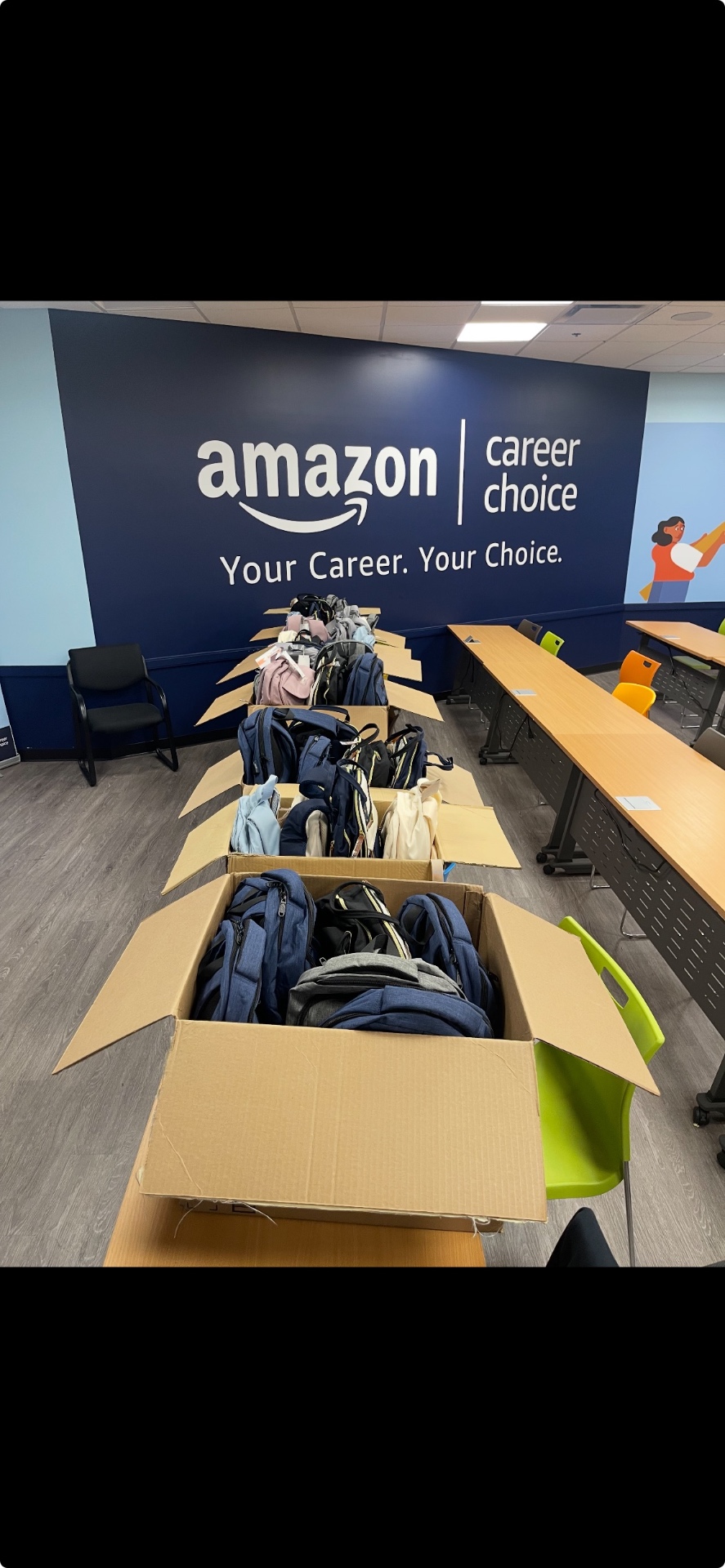 Rows of donated backpacks lined up in boxes at the Amazon Career Choice room ready for pickup