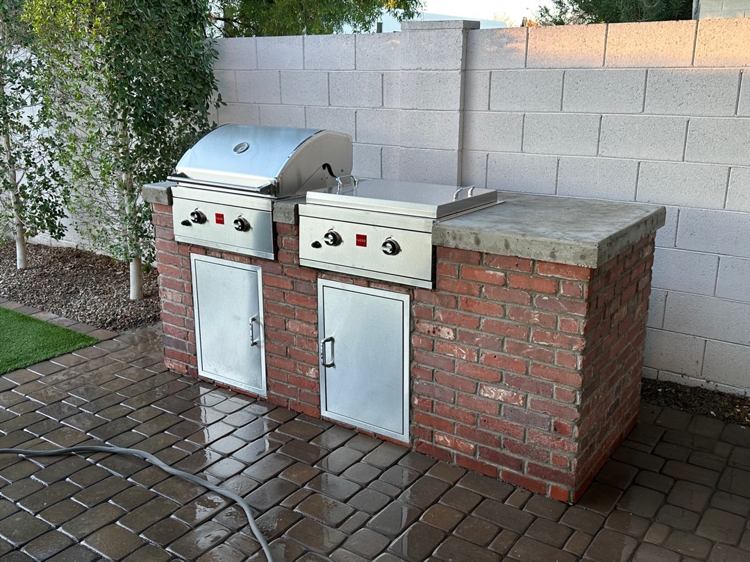 Concrete cap and brick jointing detail on a custom BBQ island against a block privacy wall.