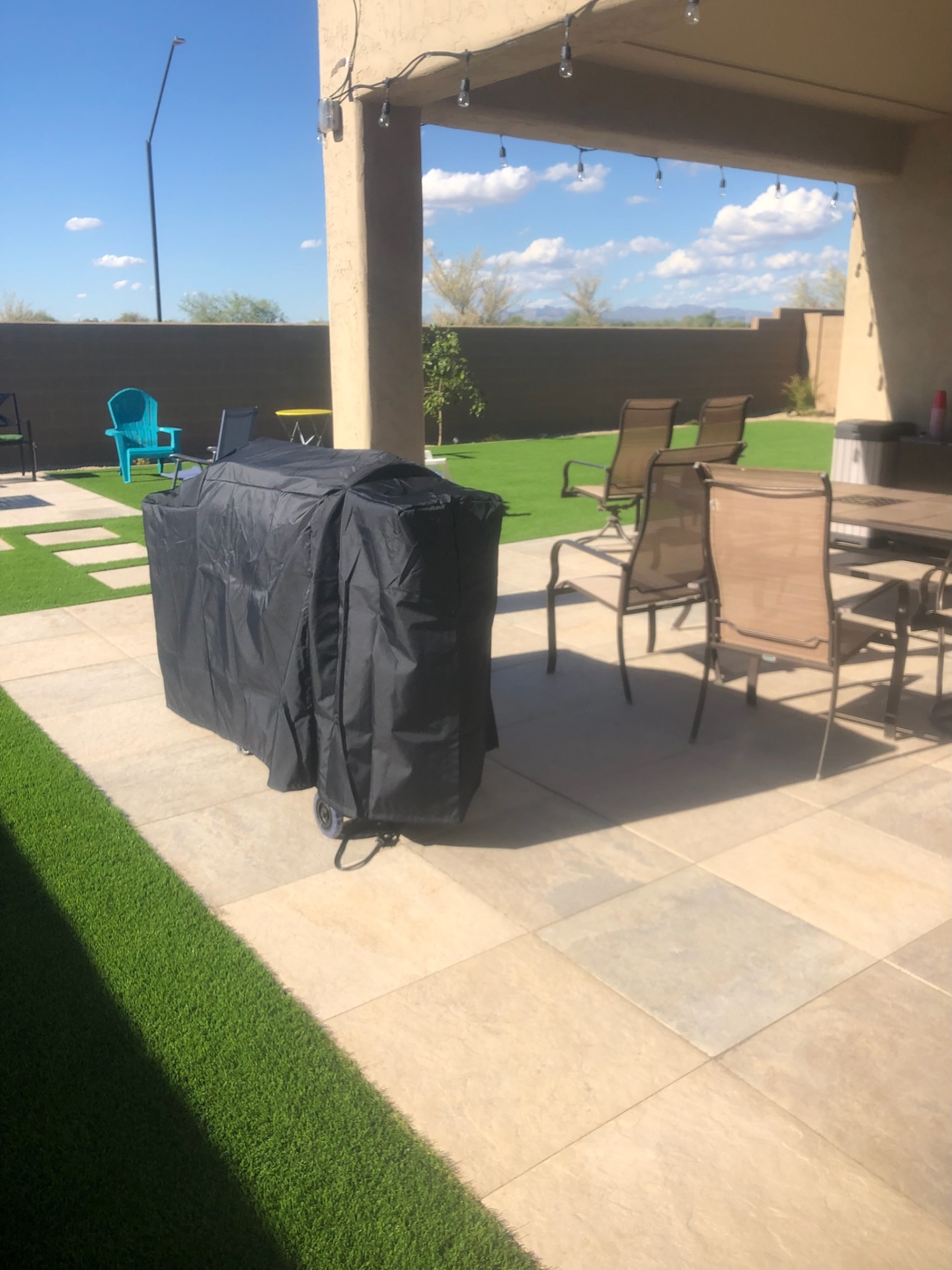 Buckeye paver patio dining area under covered pergola with turf sight-line