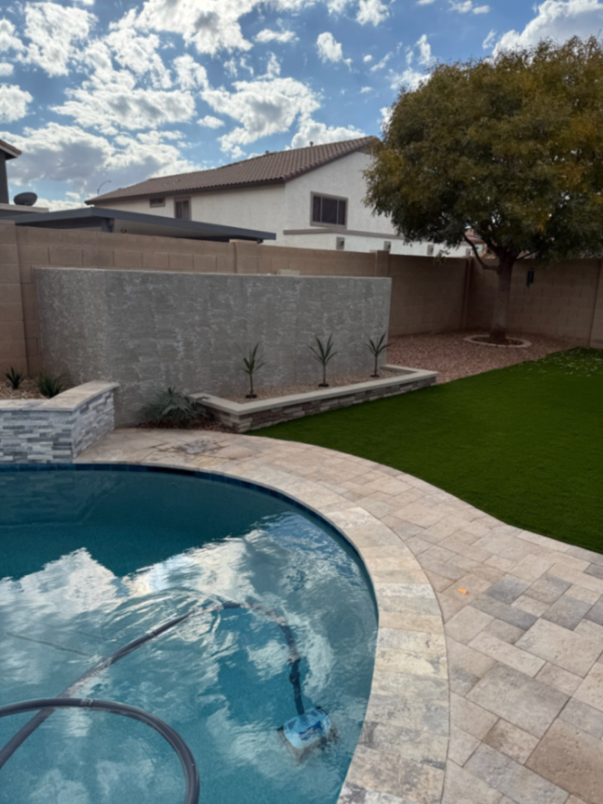 Thorn residence, Mesa AZ — pool, travertine paver deck, freestanding water-feature wall, and turf lawn.
