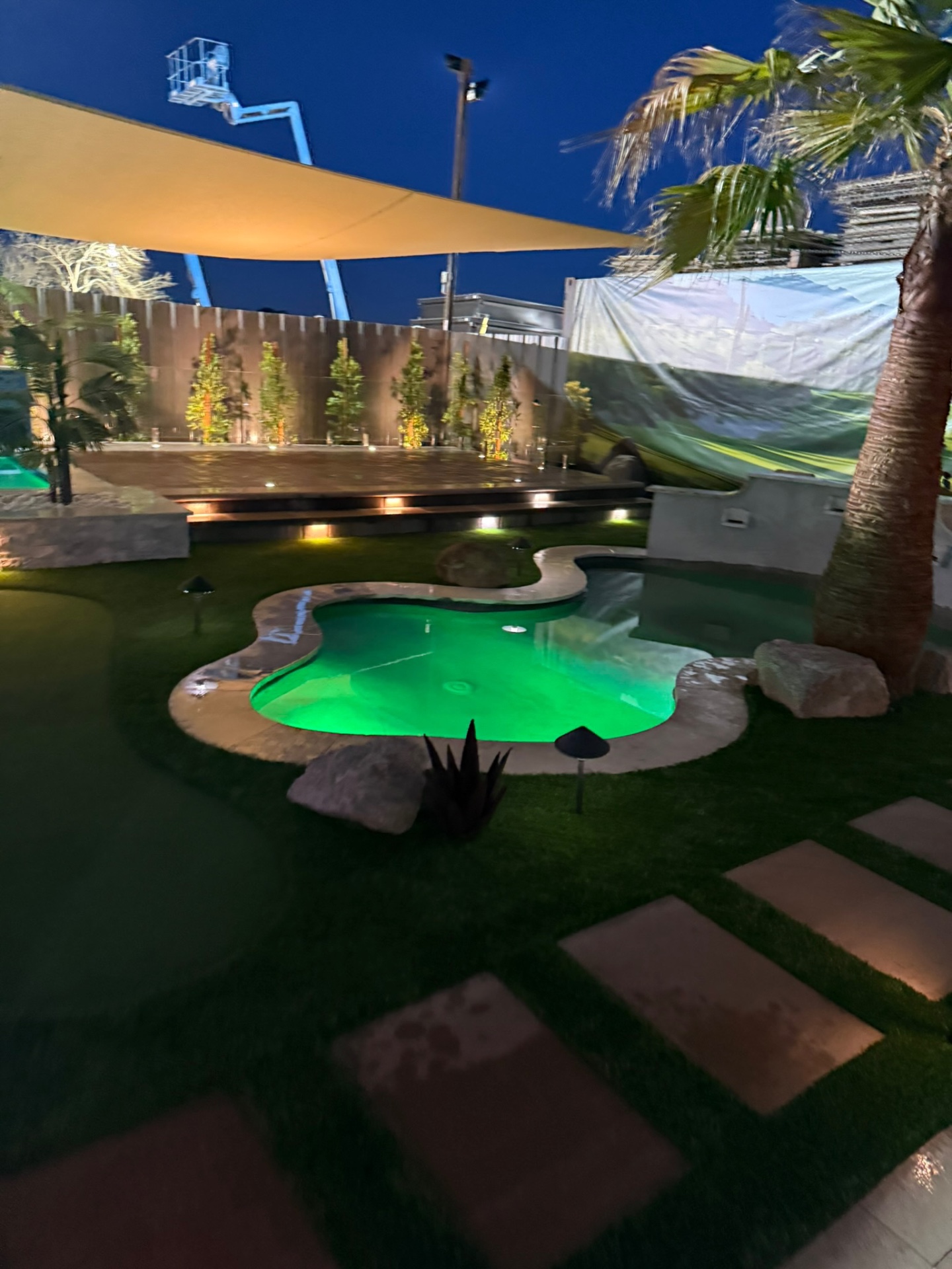 Bone-shaped mini pool with green LED lighting and stepping-stone path