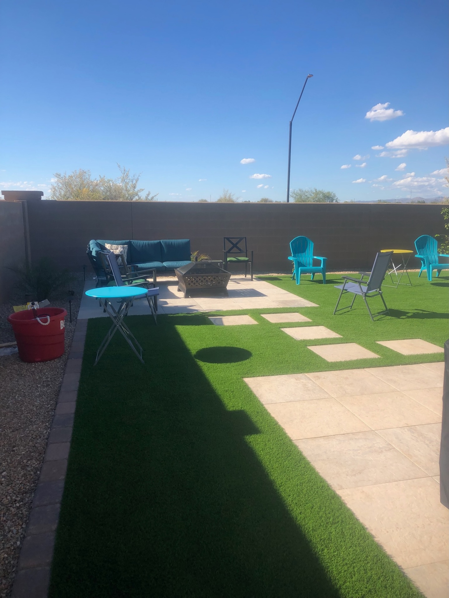 Buckeye backyard travertine paver patio with fire pit, turf, and paver ribbon detail