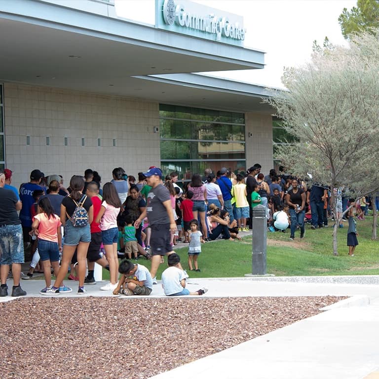 Families lined up outside the Peoria Community Center for an AE Outdoor Living backpack drive