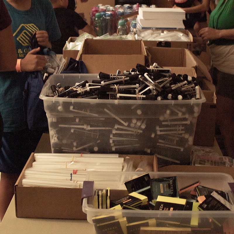 Bins of Arteza markers, pencils, and art supplies stocked for the backpack drive