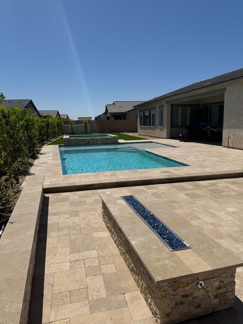 Peoria backyard custom pool and spa with travertine paver deck and linear fire feature by AE Outdoor Living