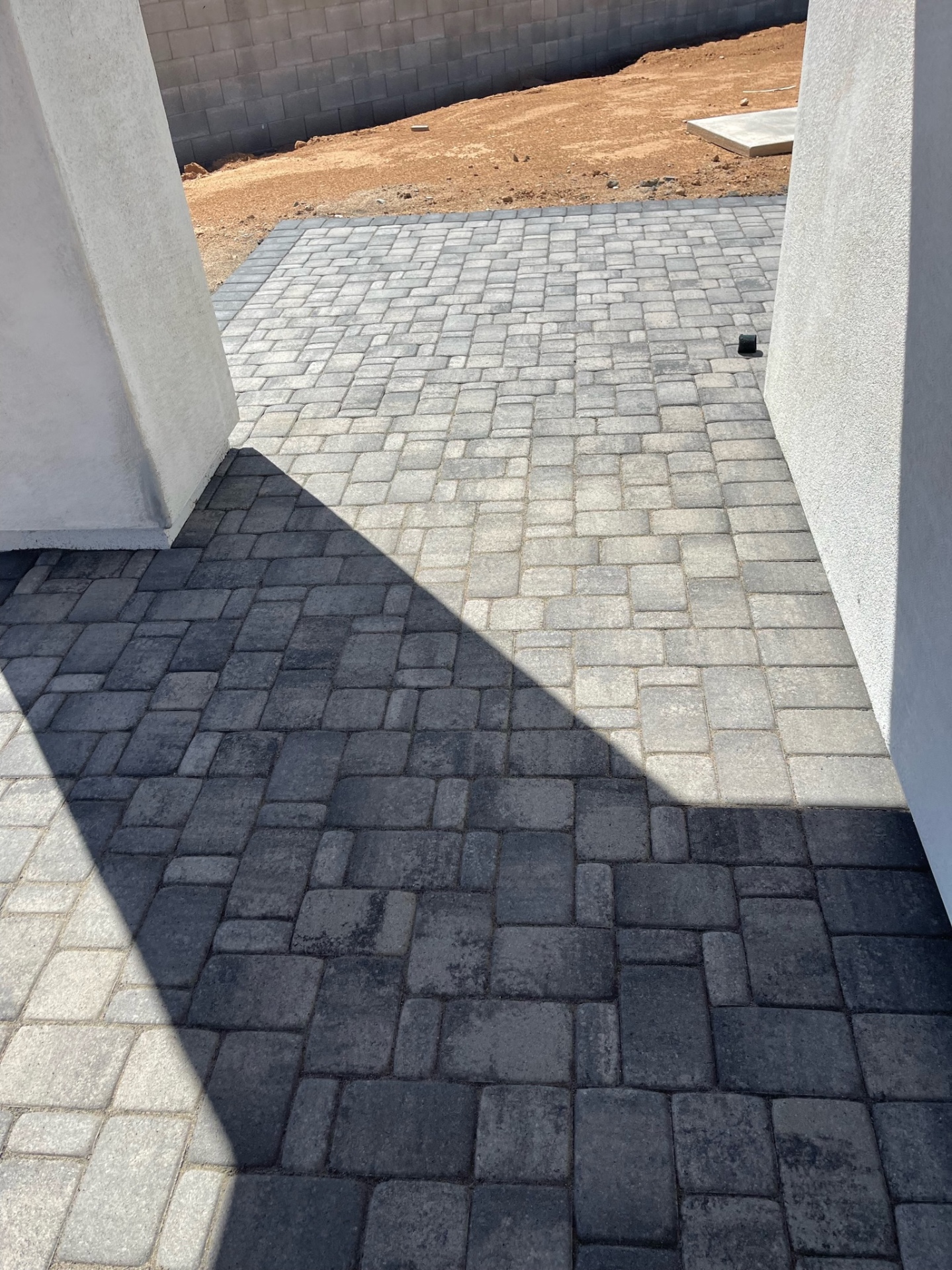 Waddell (Surprise-area) side-yard paver run with contrasting charcoal and light-grey tumbled paver bands between the home and block wall by AE Outdoor Living