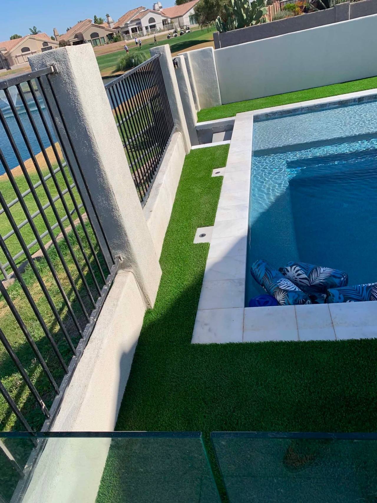 Custom Arizona pool with travertine deck, raised spa, and water features by AE Outdoor Living