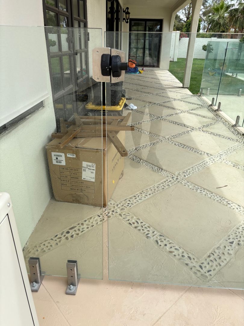 Vacuum suction cup attached to a glass panel above a paver-deck finish.