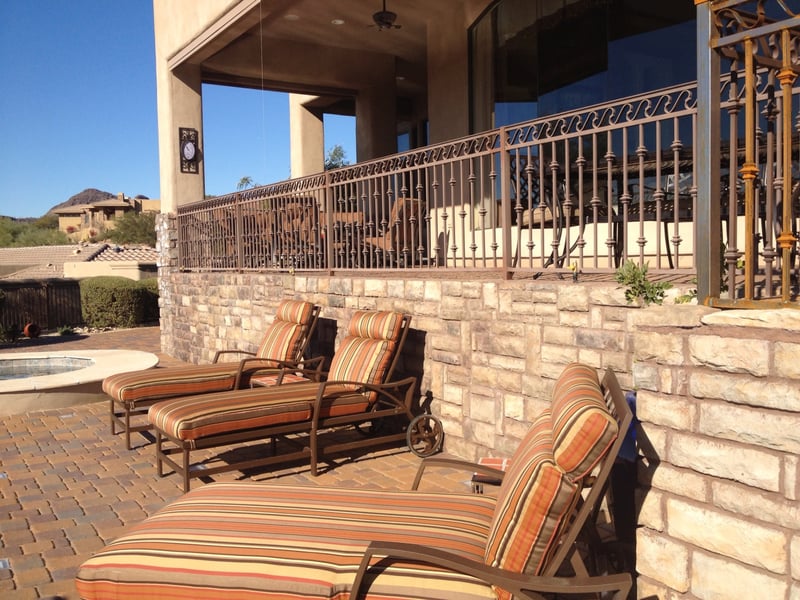 Fountain Hills elevated paver pool deck with raised stacked-stone seat wall, in-deck spa and wrought-iron view fencing by AE Outdoor Living