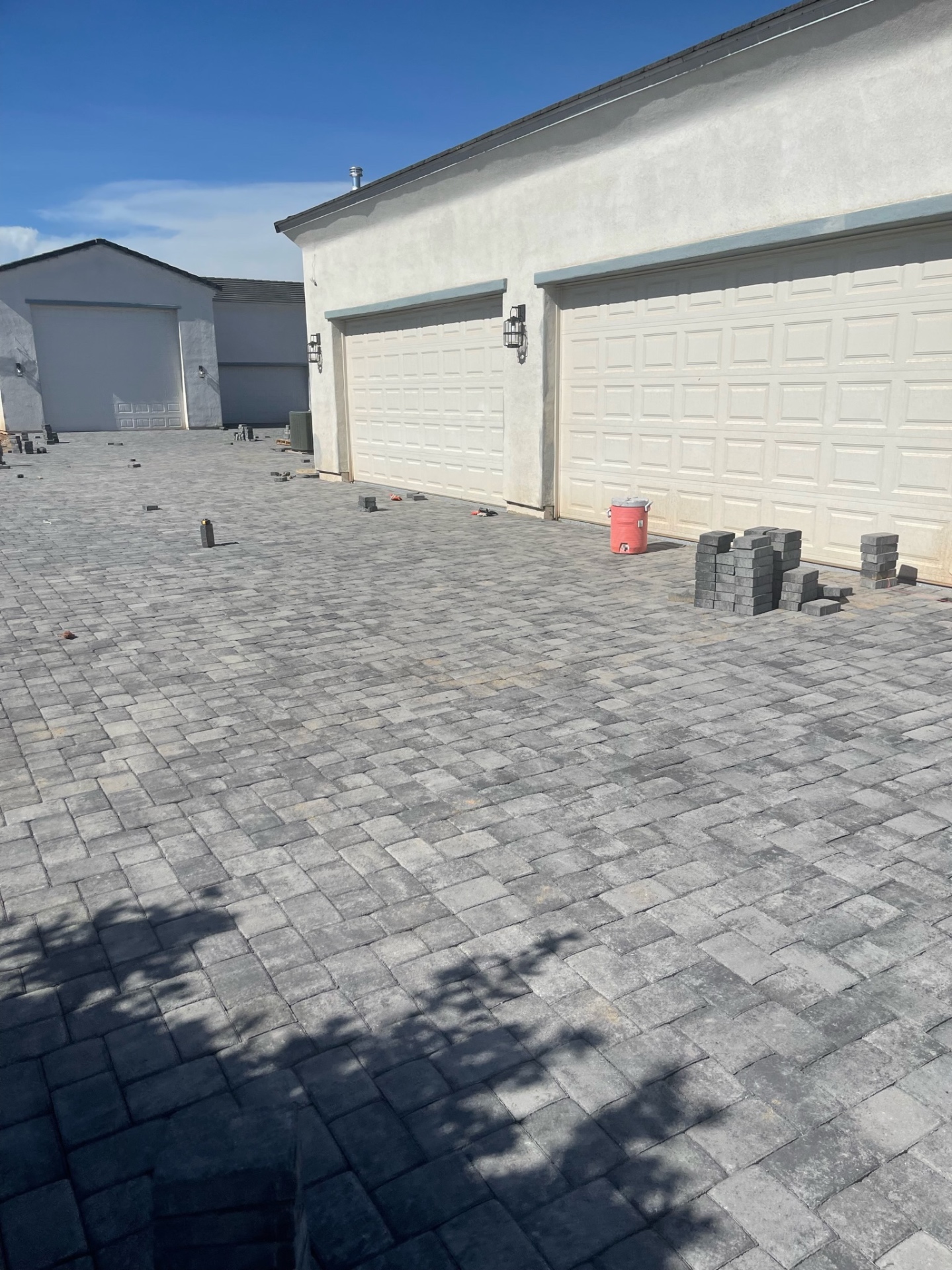 Waddell (Surprise-area) completed charcoal paver driveway apron in front of three-car garage on custom-home lot by AE Outdoor Living