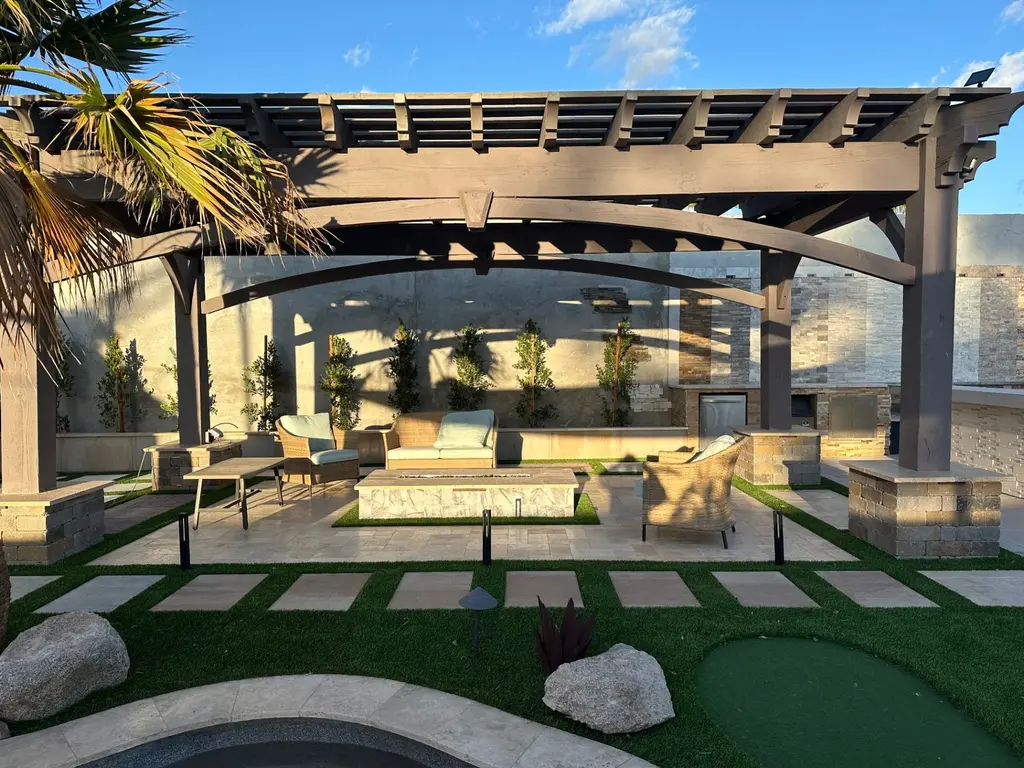 Completed AE Outdoor Living project — wood pergola, outdoor kitchen, travertine hardscape and turf in the Phoenix metro