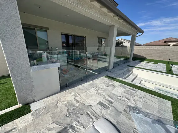 Frameless glass pool fence on porcelain marble-look pavers with 316 stainless spigots — installed by Sonoran Glass & Fence in the Phoenix metro.