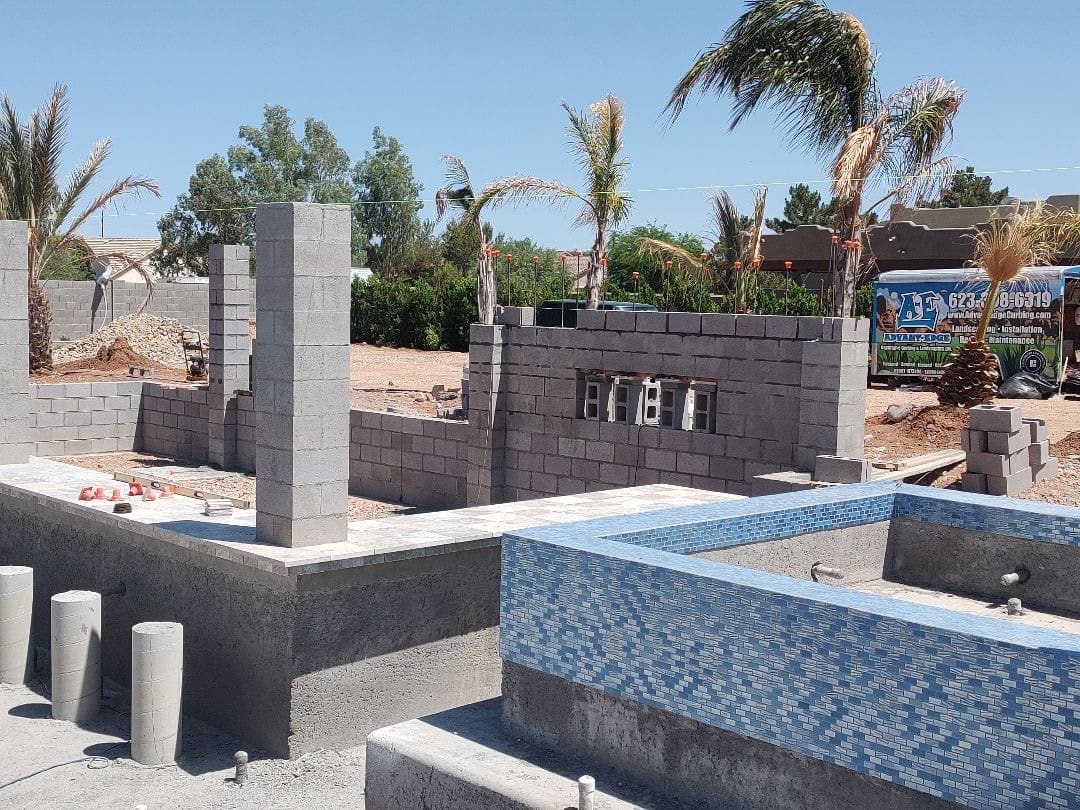 AE Outdoor Living work truck on the jobsite with block walls and pool under construction
